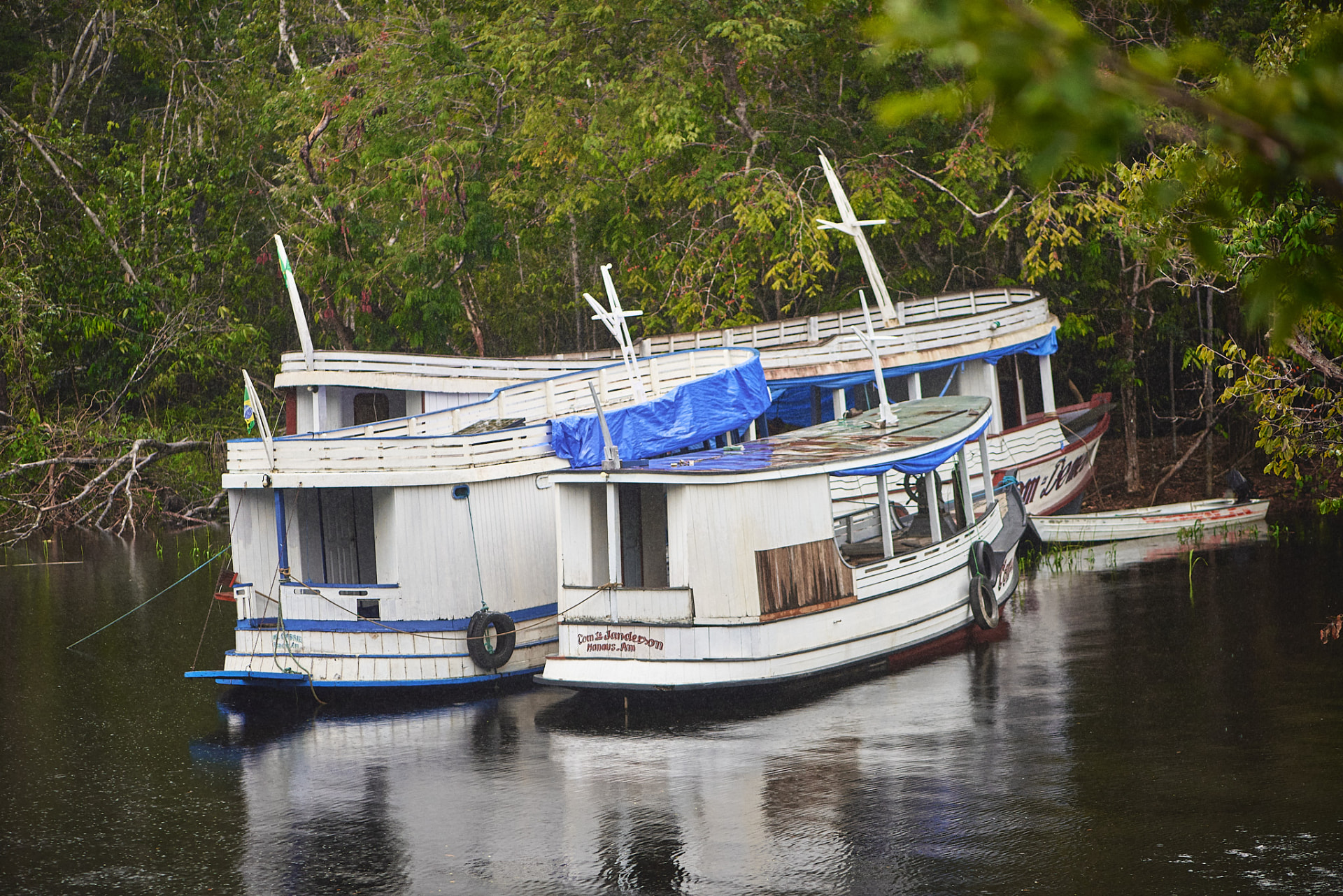 Barcos de madeira atracados às margens do rio na floresta