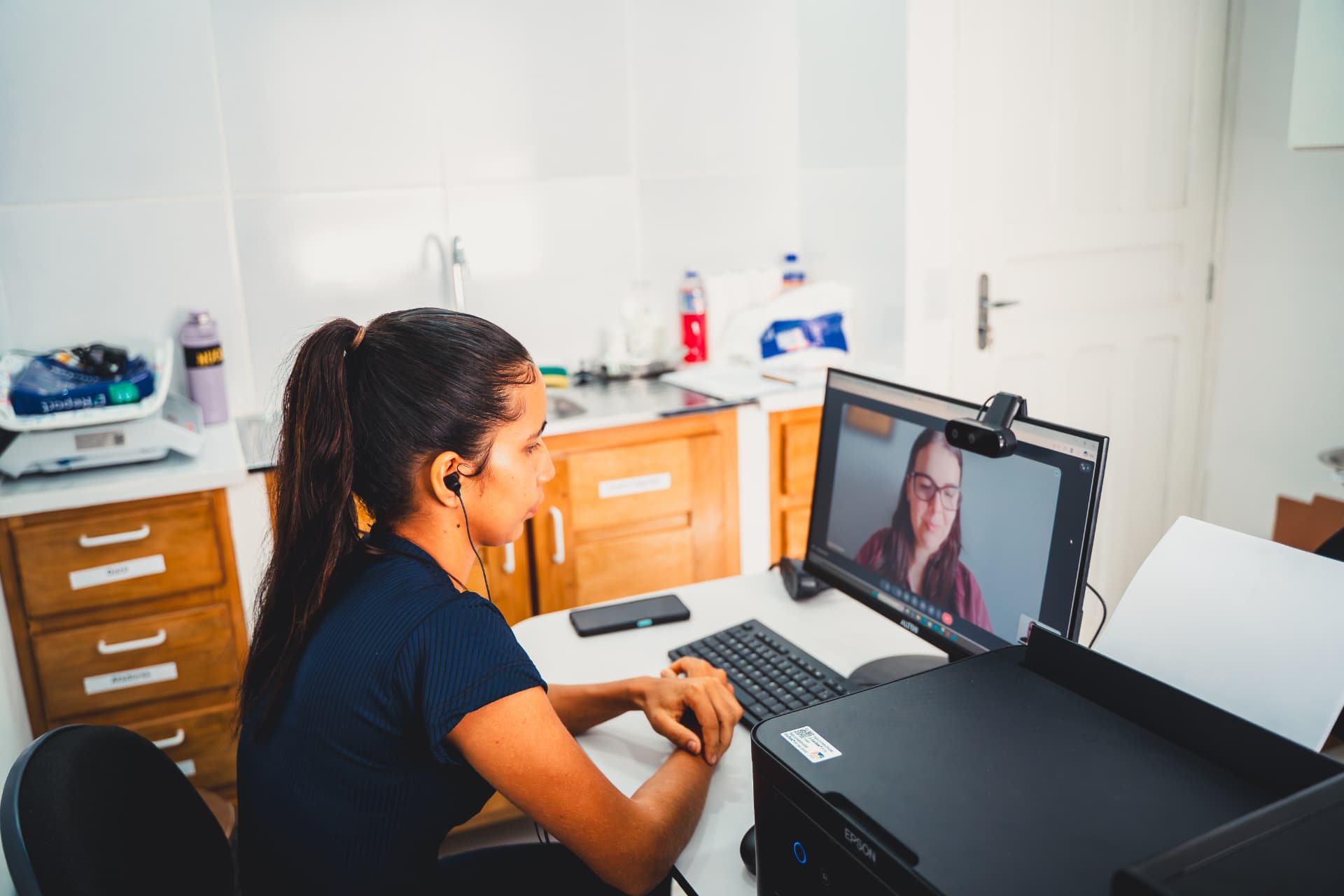 Profissional de saúde em atendimento de telessaúde por videochamada em comunidade amazônica