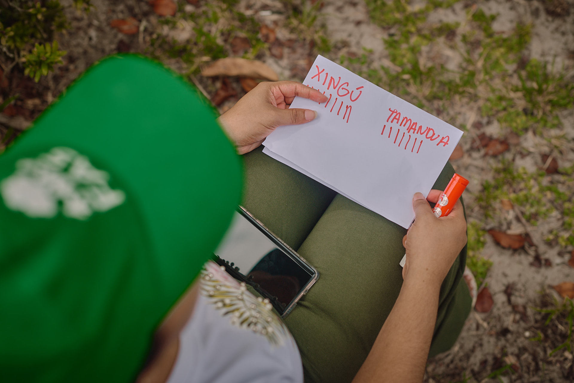 Jovem organizando material didático produzido em oficina de educação ambiental